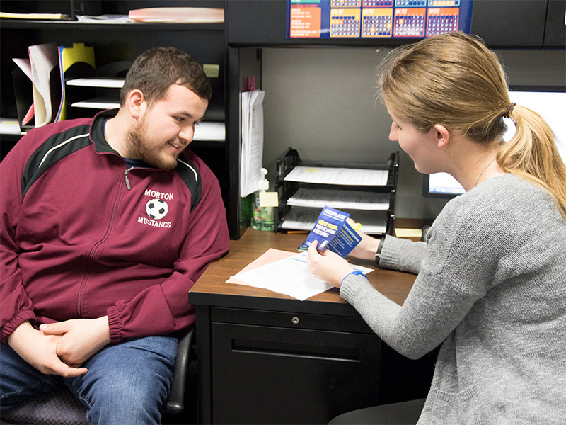 Staff member explaining cost of college. 