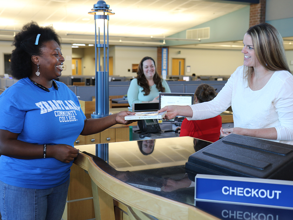 student checking out book at librarydesk