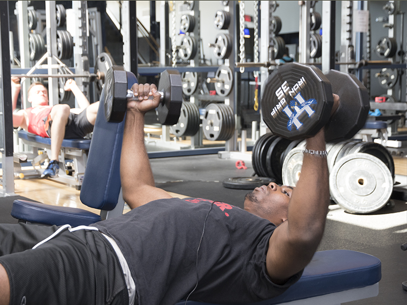 Student lifting free weights